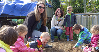 Bildung Kinder und Erwachsene spielen im Sandkasten