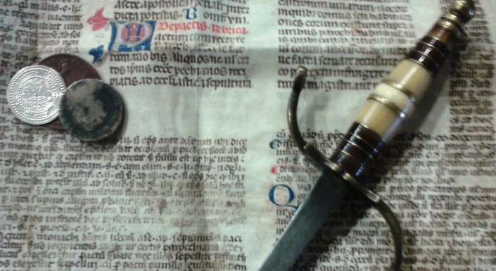 Thaler, old newspaper and a sword