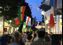 Downtown decorated with various country flags with many passers-by