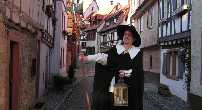 City guide in a night watchman's robe