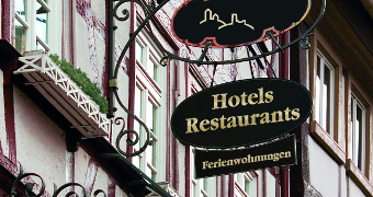 Sign on half-timbered house facade indicating hotels and restaurants