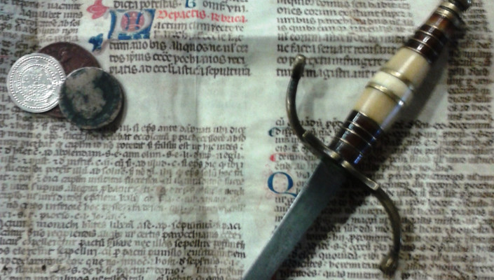 Thaler, old newspaper and a sword