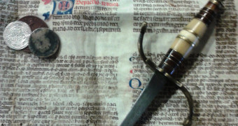 Thaler, old newspaper and a sword