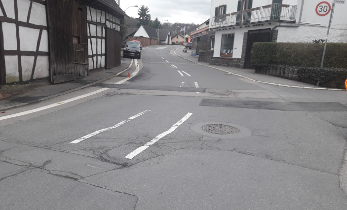 Straßenkreuzung mit maroder Straßendecke