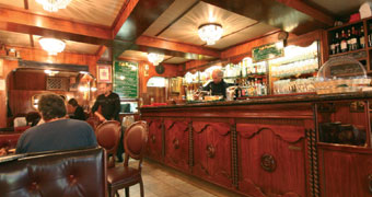 Innenraum des Café Florian mit Theke aus dunklem Holz und strahlenden Deckenleuchten